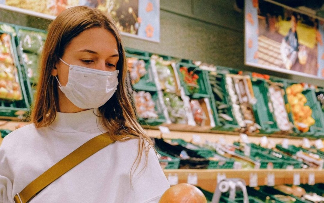 Woman inspects produce in supermarekt