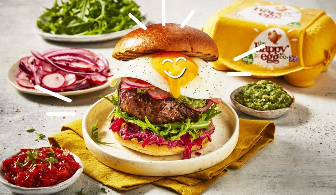 image of a burger with an egg on top and happy egg co branding